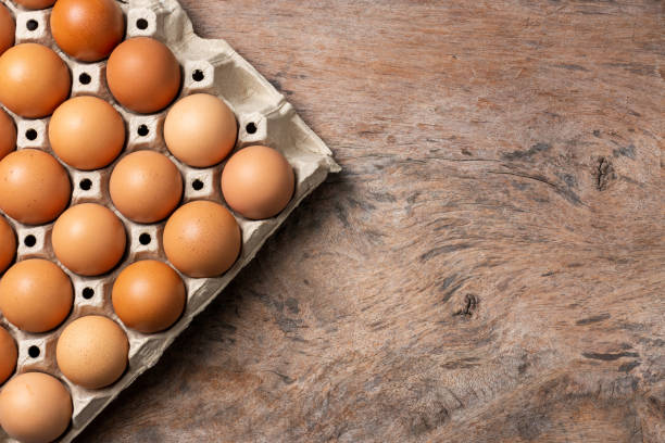 istock Chicken eggs in carton box on wooden table background. 1331745448