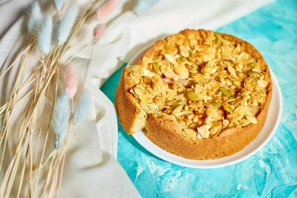 istock Apple or pear pie, tart with caramel nuts on blue table with sunlight 1331747835