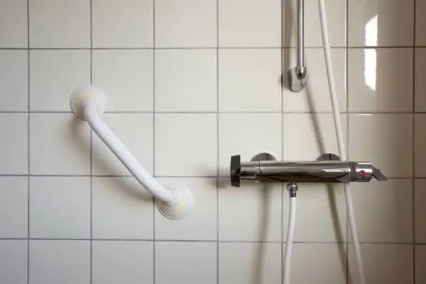 Shower and handrail,grab bar for elderly people at the bathroom in hospital or retirement home , safty and medical concept close up