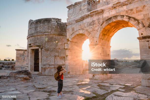 Photographer Tourist Girl Is Taking Photos Of The Frontinus Gate In Ancient Ruins In Hierapolis Pamukkale Stock Photo - Download Image Now