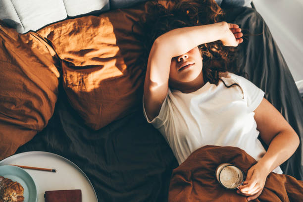 vue de dessus de la femme allongée sur le lit de mauvaise humeur. femme malheureuse à la maison seule. - fatigue photos et images de collection