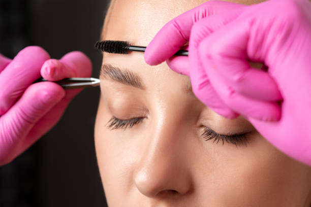 istock Makeup artist combs  and plucks eyebrows after dyeing in a beauty salon.Professional makeup and cosmetology skin care. 1331755478