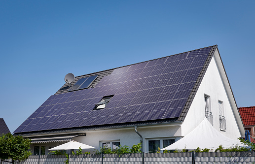 Rommerskirchen - July 21, 2021: Solar panels on the roof of a white house in the new housing area of Rommerskirchen, (close to Cologne), North Rhine Westphalia.