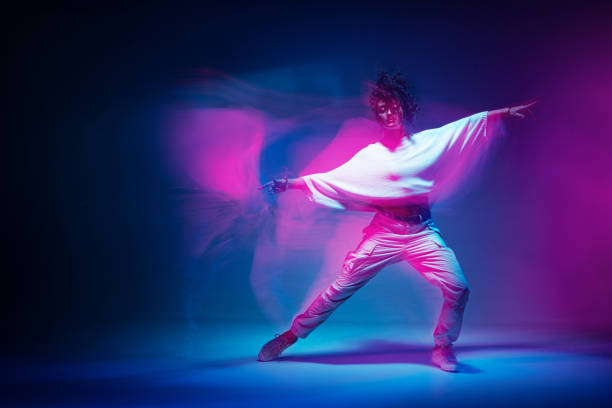 istock Mixed race female dancing in colorful neon light. Studio photo with long exposure. Expressive contemporary hip hop dance 1331758015
