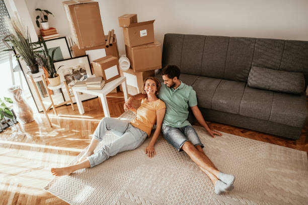 family moving in new apartment, lying on carpet and sharing love and happiness after moving in. - moving house apartment couple box imagens e fotografias de stock