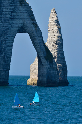 France, Normandy, sailboats and rock formation in Etretat on the coast of English Channel, a preferred travel destination and sea resort