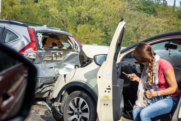 Woman Sitting In Car With Met With An Accident Seeking For Help Using Cellphone