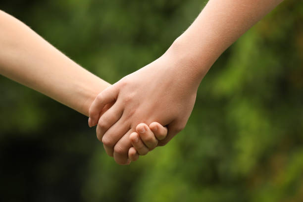 istock Woman and child holding hands outdoors, closeup 1331764991