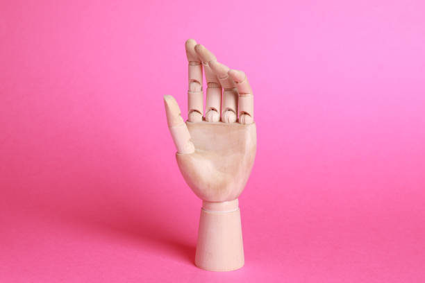 Wooden hand model on pink background. Mannequin part