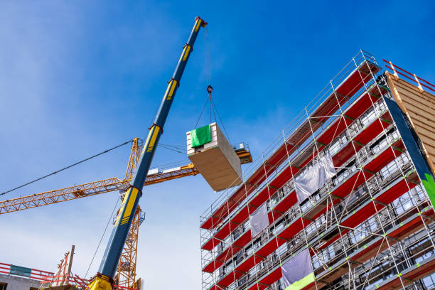 istock Crane lifting a wooden building module to its position in the structure. The new structure will be built in modular timber construction. 1331765401