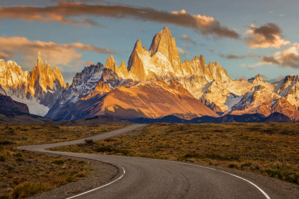 un camino ventoso conduce al monte fitz roy, las montañas circundantes y la ciudad de el chalten, argentina - patagonia fotografías e imágenes de stock