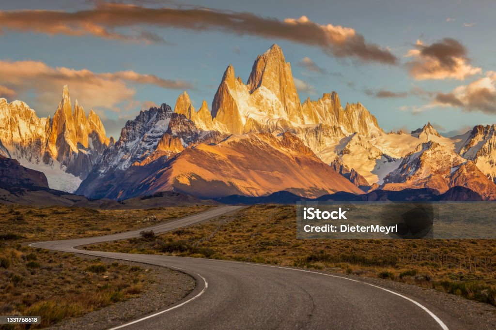A windy road leads to Mt. Fitz Roy, surrounding mountains and the town of El Chalten, Argentina Argentina, Chalten, Patagonia - Argentina, Mt Fitzroy, Winding Road Argentina Stock Photo
