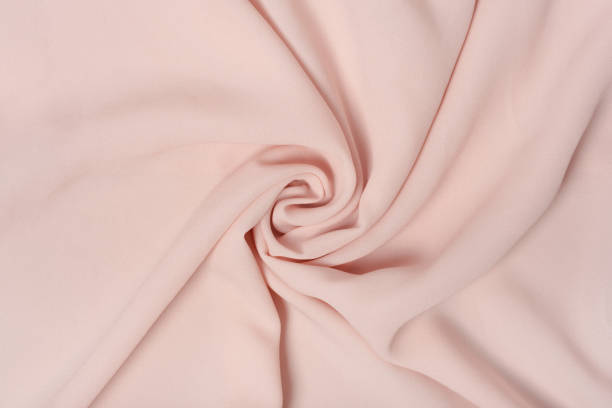 istock Soft pink deluxe quality polyester fabric is rolled up in beautiful waves. Background 1331770351