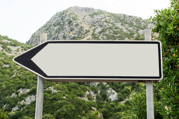 istock Road blank sign with arrow against mountains. 1331770494