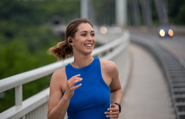 Young woman jogging on bridge stock photo