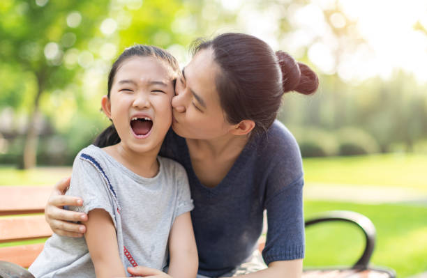 istock Mother kissing daughter 1331780584