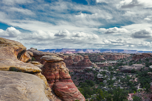 Mountain landscape with red rocks under a cloudy sky in Canyonlands National Park.