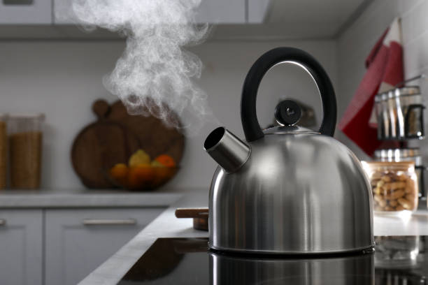 istock Steaming kettle on electric stove in kitchen 1331781986