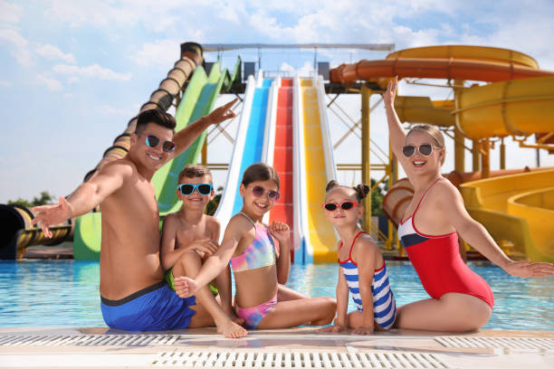 istock Happy family at poolside in water park 1331782320