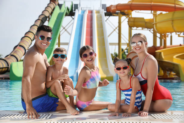 istock Happy family at poolside in water park 1331783570