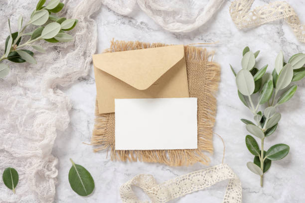 istock Blank card with envelope laying on a marble table decorated with eucalyptus branches 1331783916