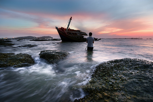 An old shipwreck or abandoned shipwreck.,Wrecked boat abandoned stand on beach or Shipwrecked off the coast of Thailand.