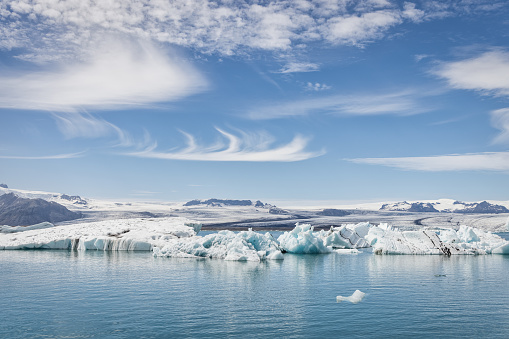 Blue ice occurs when snow falls on a glacier, is compressed, and becomes part of the glacier. During compression, air bubbles are squeezed out so ice crystals enlarge. This enlargement is responsible for the ice's blue color.