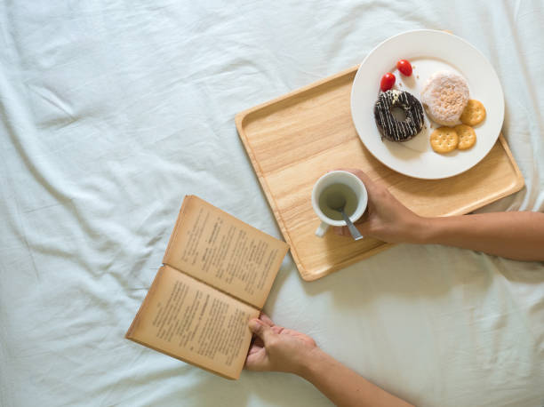 istock Tray With Breakfast On BedWooden tray with served breakfast lying on bed blanket with opened book. 1331788926