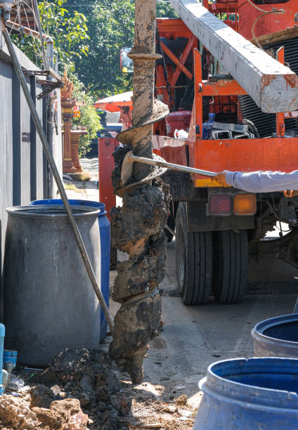 istock big truck use electric drill pole digger soil ground for install long concrete pole. deep hole destroy by heavy machine. 1331789376