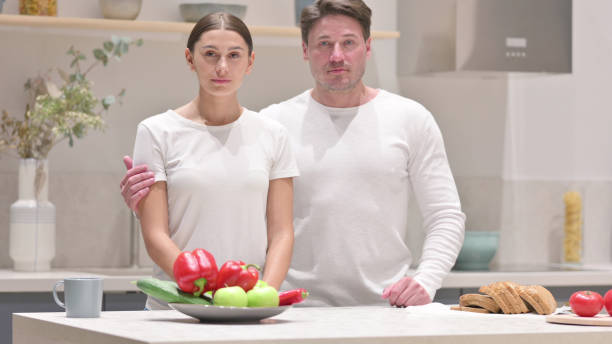 istock Mixed Race Couple Looking at Camera in Kitchen 1331795021