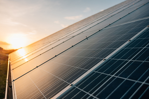 Close-up of solar panels against sky during sunset