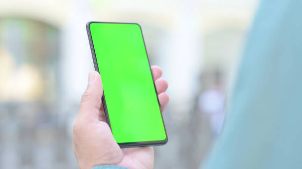 istock Outdoor Man Holding Smartphone with Green Chroma Key Screen 1331795408