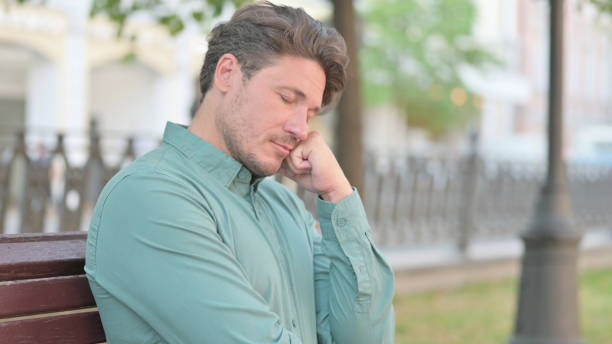 istock Portrait of Man Taking Nap on Bench 1331796398