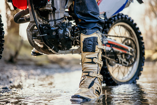 Low section of motocross rider on a stream in forest
