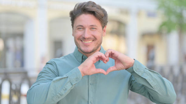 istock Outdoor Middle Aged Man showing Heart Shape by Hands 1331796938