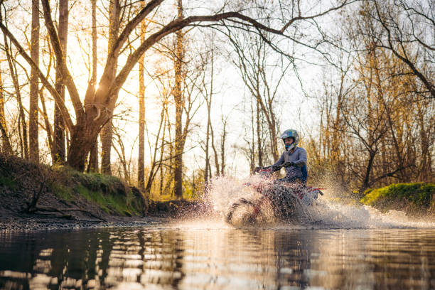 istock Motocross rider riding a stream in forest 1331797108