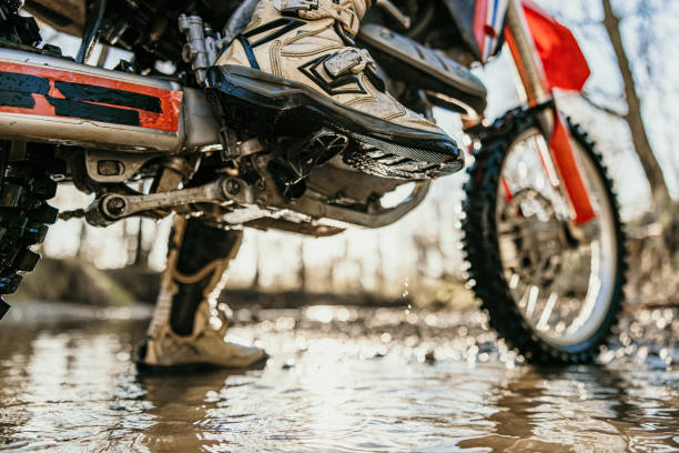 istock Motocross rider riding through stream in forest 1331797161