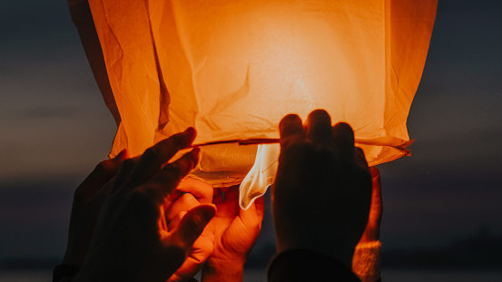 Human hands about to release burning sky lantern