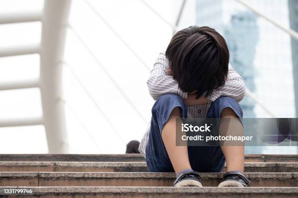 Homeless Asian Child Sitting Alone On The Stairway In The Street Poor Sad Scared And Alone Stock Photo - Download Image Now