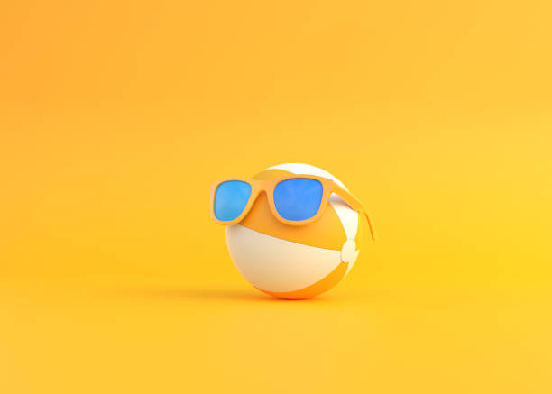 ballon de plage portant des lunettes de soleil sur fond jaune - beach ball summer ball isolated photos et images de collection