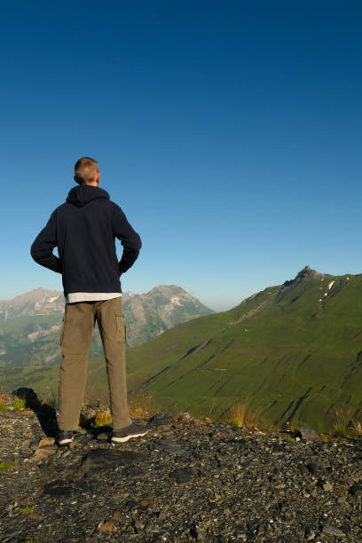 istock A man from the back, facing green mountains. 1331802804