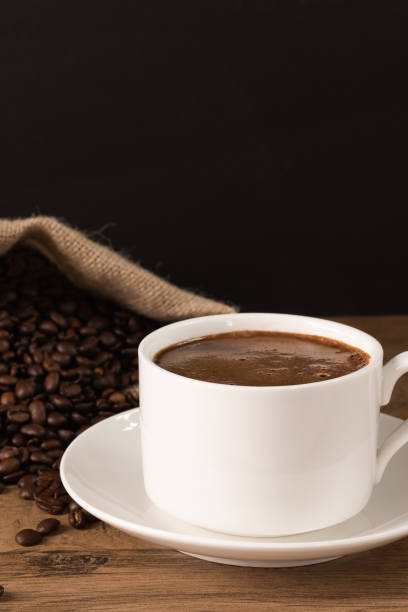 coffee cup and saucer on wooden background with roasted coffee beans. - sack burlap bag roasted imagens e fotografias de stock