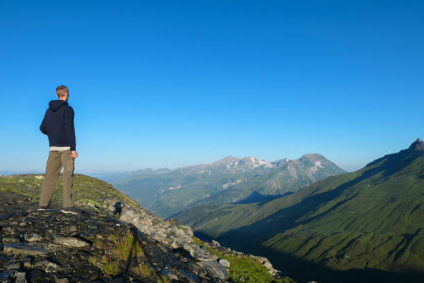 istock A man from the back, facing green mountains. 1331803032
