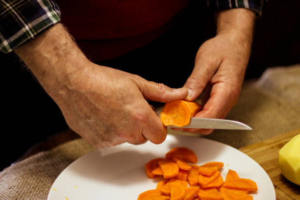 istock A man cuts carrot into slices to make soup 1331804205