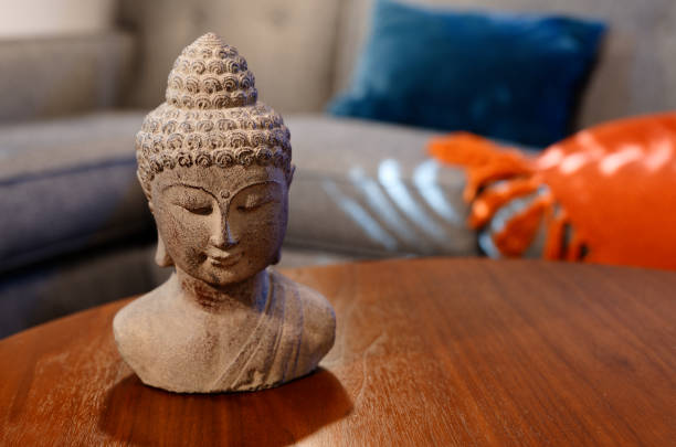 istock Buddhist statue resting on wooden table in den 1331804384