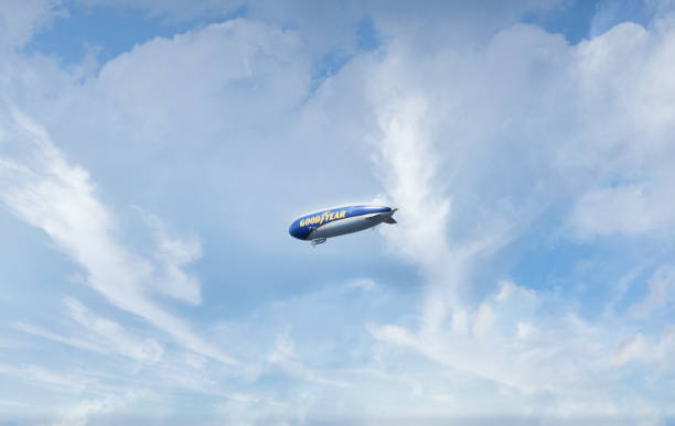 dirigeable volant dans le ciel bleu. espace de copie. - goodyear blimp photos et images de collection