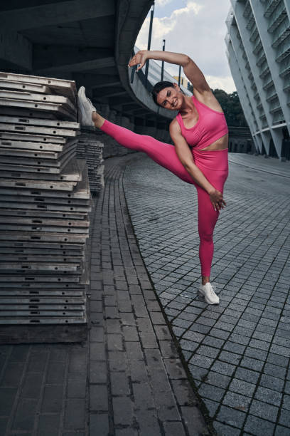 istock Woman posing for camera with raised right leg 1331806759