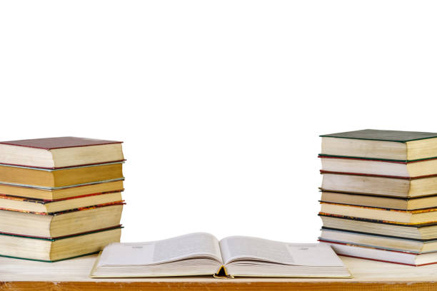 An open textbook and stacks of books on the reading desk. Learning concept. Isolated on white background