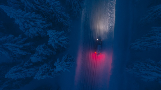High angle view of car traveling on road in snow covered forest
