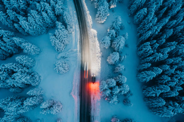 istock High angle view of car on road in snow covered forest 1331810721